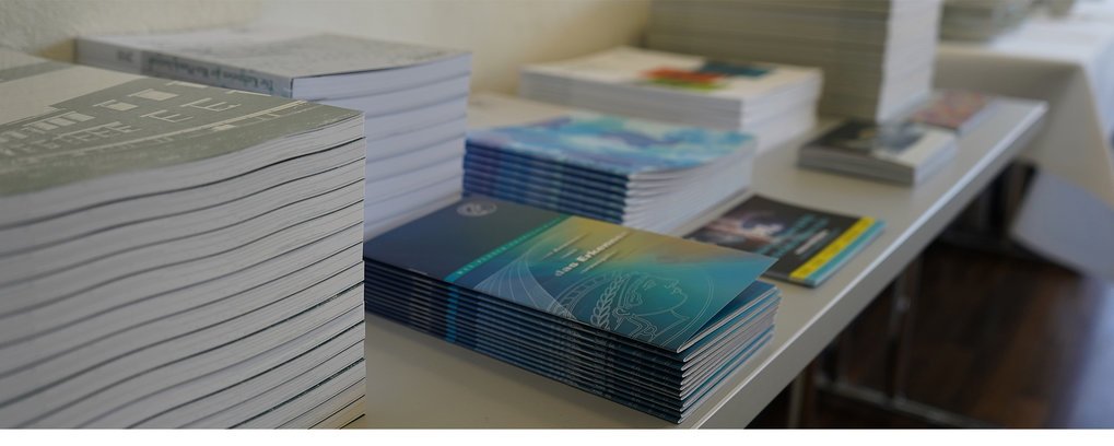 The image shows a table with different flyers and booklets.